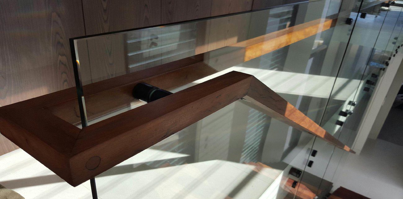 A frameless glass balustrade by Artform Collective with a dark wood handrail for the stairs.