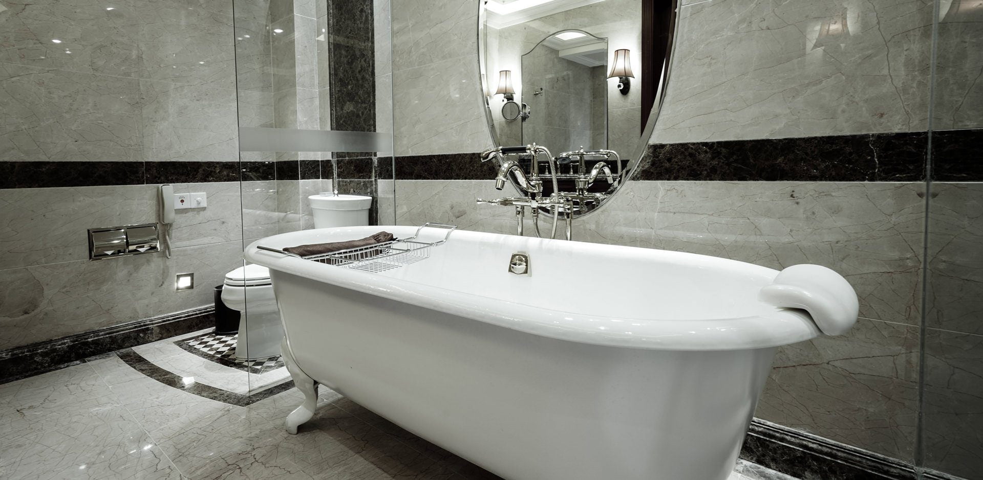 A clawfoot tub with a frameless glass shower screen by Artform Collective.